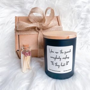 friendship candle sat in front of the gift box with a small glass bottle next to it filled with matches