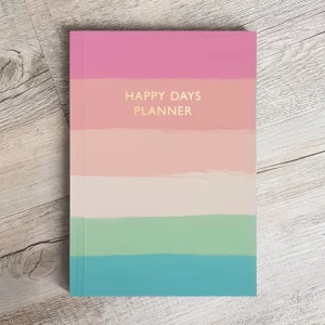 Happy days planner front cover. Colourful horizontal stripes in shades of pink, green and blue. Gold foil text with the wording Happy Days Planner.