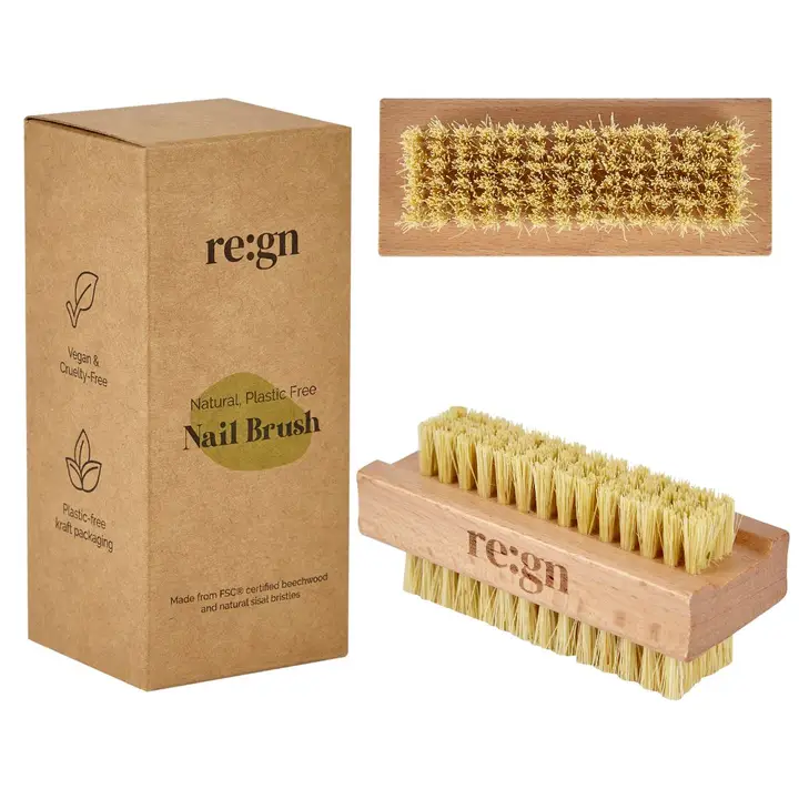 Natural bamboo nail brush sat next to a brown kraft card box